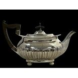 A silver teapot by Walker & Hall with a rectangular body with half fluted design, four ball feet,
