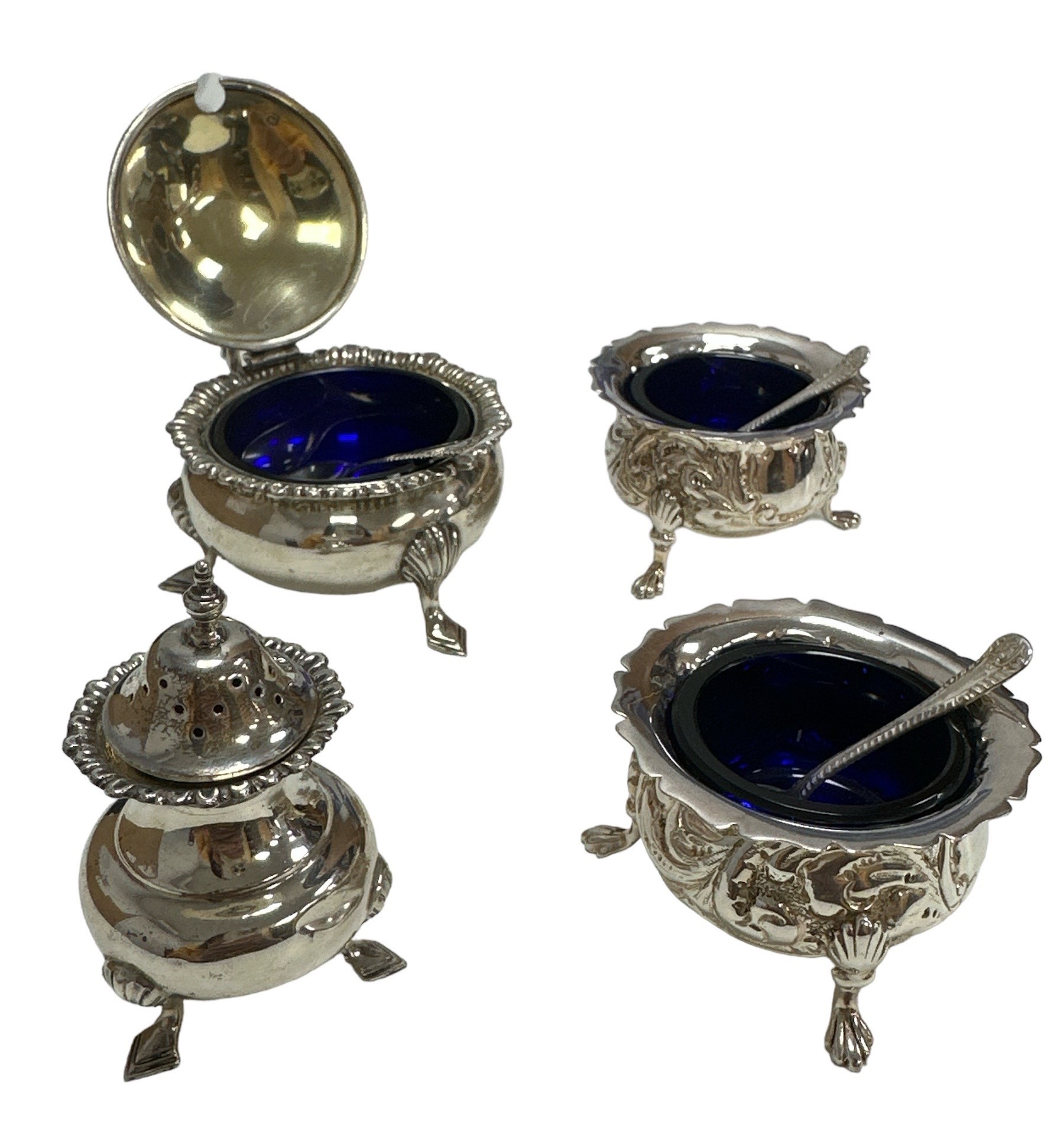 Two silver salts and a mustard pot with blue liners and spoons. Also a silver sugar shaker. Total