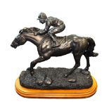 Spelter model of a racehorse and jockey on wooden base, length approx. 26cm.