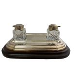 A Barker Ellis desk inkwell with wooden base and two glass bottles with white metal mounts.