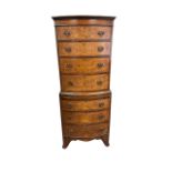 A bow fronted walnut veneer 7 drawer chest of drawers with pull out desk, in 2 parts, lower 3 drawer