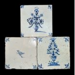 Three blue and white hand painted earthenware tiles Delft, two having vases of flowers design and