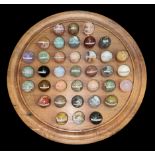 Carved hardwood solitaire board with polished and labelled geological specimen marble balls. Board