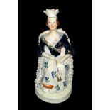 Staffordshire, a Staffordshire figure of a young Queen Victoria seated on throne, hand painted.