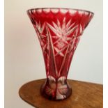 A large Ruby overlay cut crystal glass vase, waisted form. Height 21cm.