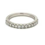 A platinum and diamond half-eternity ring, set with 13 round brilliant cut diamonds. Size L.