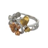 An unusual and striking tri-colour 18ct gold and diamond flowers ring.