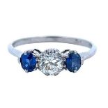 A three stone diamond and sapphire ring. Central diamond 5mm, 0.5ct approx with a sapphire on either