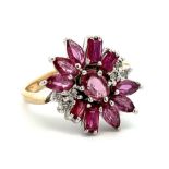 A 9ct gold ruby and diamond cluster ring. An oval ruby surrounded by marquise and baguette cut