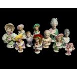 A selection of eleven German porcelain pin cushion dolls, various designs with heights varying