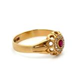 A gold and ruby ring with facetetd diamond accents in cluster style, stamped 18ct. Size P. Total