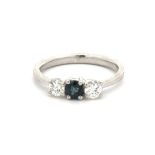 A sapphire and diamond three stone ring, set in platinum. Sapphire a teal hue. Diamond approx 0.