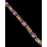 An amethyst bracelet. Five oval cut amethysts (approx 14mm x 10mm) set in a 9ct gold filigree design