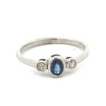 An 18ct sapphire and diamond 3 stone ring. Sapphire approx 4.5mm x 3mm. Diamond 0.06ct. Size L.