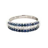 A three row sapphire and diamond ring, with two outer edges of claw-set round brilliant-cut sapphire