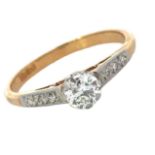 A yellow gold diamond ring, stamped 18ct, with diamond set shoulders and white claw coronet setting.