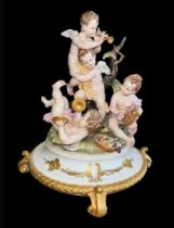 A decorative Capodimonte centrepiece featuring four cherubs / putti playing musical instruments,
