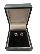 A pair of ruby and diamond cluster earrings. Set in hallmarked 9ct white and yellow gold. Please see