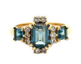 An 18ct gold and London blue topaz and diamond ring, size O. A central emerald cut topaz 8mm x 6mm