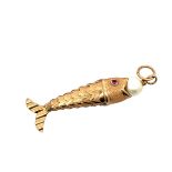 A fish-shaped articulated pendant with a pearl in its mouth and pink gem set eyes. Please see the