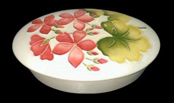 Moorcroft - A Moorcroft pottery, oval trinket box with lid, decorated with pink geranium on a