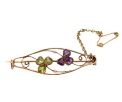 A brooch set with peridots, amethyts and seed pearls in unmarked yellow metal (tests as 9ct gold).