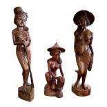 Three Balinese carved wooden female figures. The two standing figures approx. 59cm tall and the