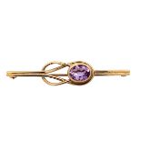 A 9ct gold bar brooch with an amethyst set in a knot design. 48mm in length. Weight 3.42g. Please