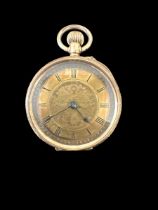 An open face pocket watch stamped 14K. Gold dial with foliate design and Roman numerals hour