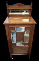 Edwardian walnut music cabinet with mirror inset upstand, the partly glazed panelled door also