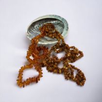 A long (approx 200cm) amber chip necklace, a faux amber necklace and an abalone shell. Please see