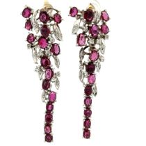 A pair of articulated ruby and diamond earrings in a floral design. Cascading rubies are