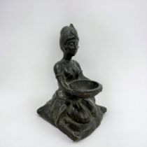 A spelter statute of a kneeling woman holding a bowl.