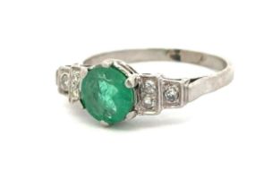 An Art Deco round cut emerald and diamond ring stamped PLAT, Size P/Q. Emerald 6.95 x 3.35mm, approx