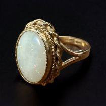 A 9ct opal ring - oval opal cabochon with gold rope twist surround, size Q. Small crack in the