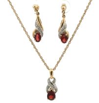 A white and yellow gold necklace and earrings set with garnets and white stone accents. Pendant