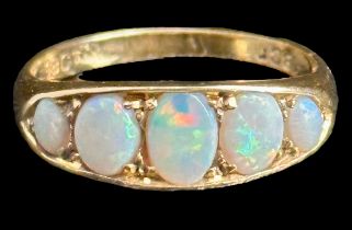 A five stone opal ring, stamped 18ct. Opals show full spectrum of colour. Size M, weight 3.75g.