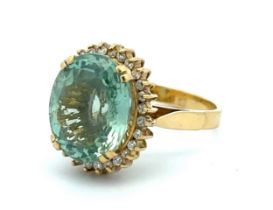 An oval cut aquamarine and diamond cluster ring set in 18ct gold. Aquamarine is approx 15mm x 12mm