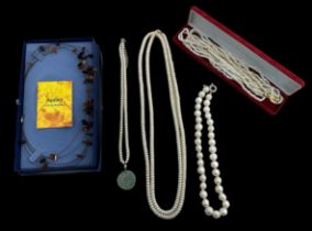 Four cultured pearl necklaces including one with a jade pendant attached and another with a clasp