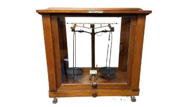 F.E. BECKER & CO. Scientific beam balance with boxed weight in glazed display case.