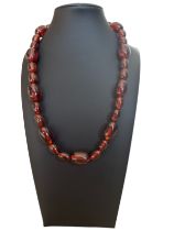 A pressed amber bead necklace made up of a sequence of different sized amber beads. Approx 21 inches
