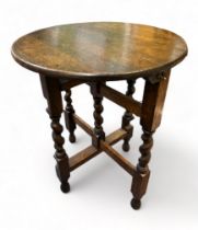 Small oak folding round coffee table on four barley twist legs. Height 53cm, diameter 44cm. Buyer to