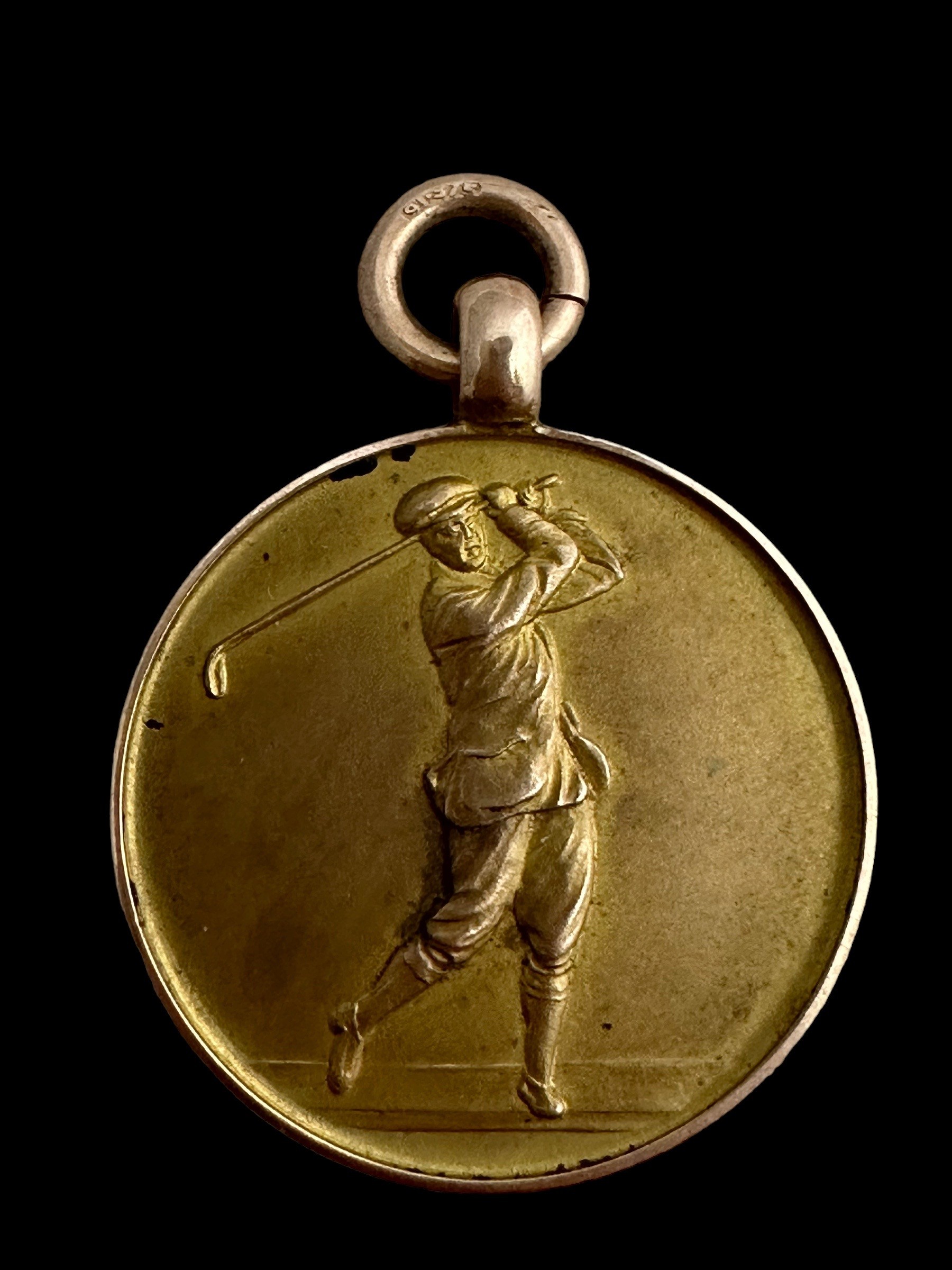 A 9ct gold medallion on a yellow metal chain. Medallion with a profile of a golfer on one side and