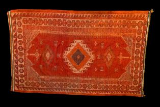 Turkish hand woven orange/red ground rug, with a central geometric medallion, two diamond medallions