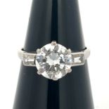 A diamond solitaire ring, estimated 2.32ct with baguette diamond shoulders. Diamond is lively.