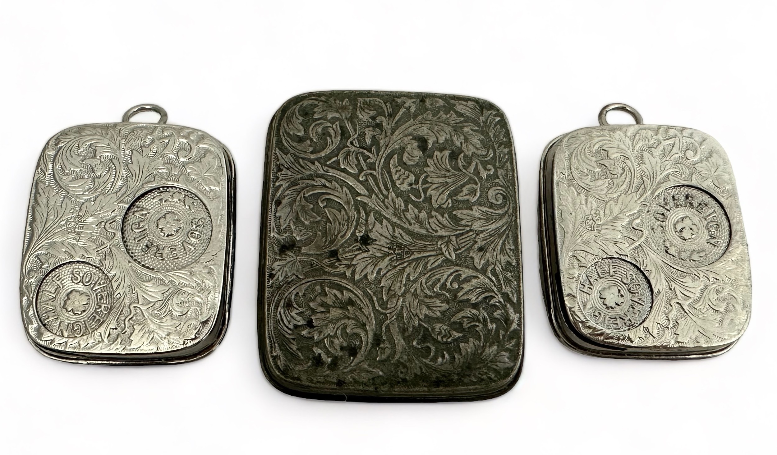 Three white metal sovereign holders with foliate design. Two with dimensions of approx 50mm x