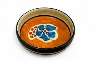 Clarice Cliff - Bizarre Nuage circular pin tray, internally decorated with blue flowers on an orange