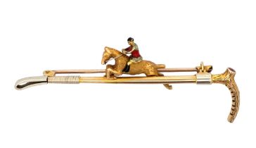 A 9ct gold bar brooch in the form of a riding crop with a gold and enamel horse and jockey. Set with