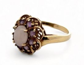 An amethyst and white cabochon stone cluster ring, hallmarked 9ct gold. Size R. Weight 3.58g. Please