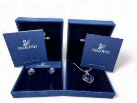 A Swarovski crystal heart-shaped pendant with a purplish-blue hue on a Swarovski chain together with